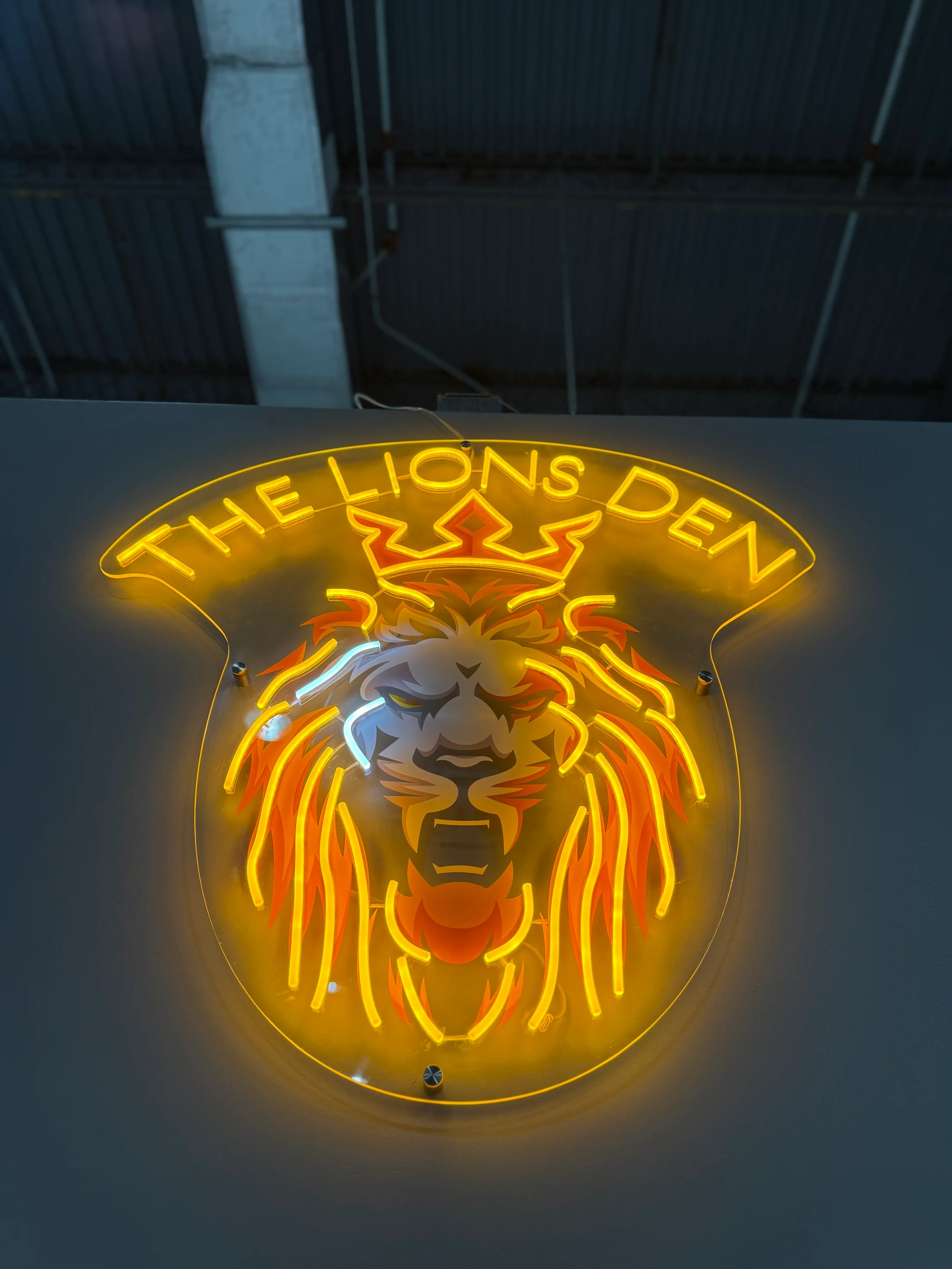 The illuminated Lions Den sign inside the real gym